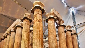 Eine Reihe alter Steinsäulen mit aufwendigen Kapitellen, vermutlich Teil einer historischen oder archäologischen Stätte.
