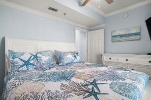 Ein Schlafzimmer mit einem Bett, einem Schminktisch, einem Bild und einer Tür.