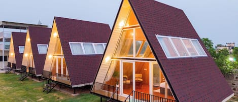 Une rangée de chalets en forme de «
A
» dotés de grandes fenêtres et d’une terrasse en bois.