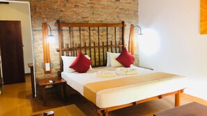 Une pièce avec un mur en briques, un lit en bois avec une tête de lit, une table de chevet et une commode.