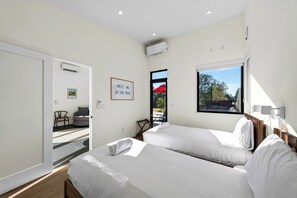 A hotel room with two beds, a framed sign on the wall, and a view of the outdoors. - Lap Pool + Sauna + Outdoor Kitchen | 40 Acres, Glen Ellen | Olive & Oak (Glen Ellen)