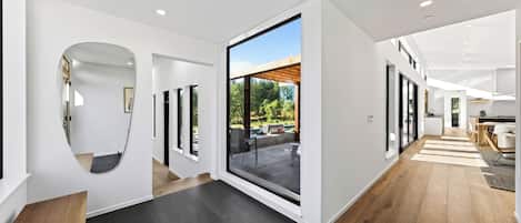 Et moderne interiør med et åbent centralt område, der fører til en patio.