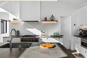 A modern kitchen with a central island, stainless steel appliances, and a minimalist design. - Lap Pool + Sauna + Outdoor Kitchen | 40 Acres, Glen Ellen | Olive & Oak (Glen Ellen)