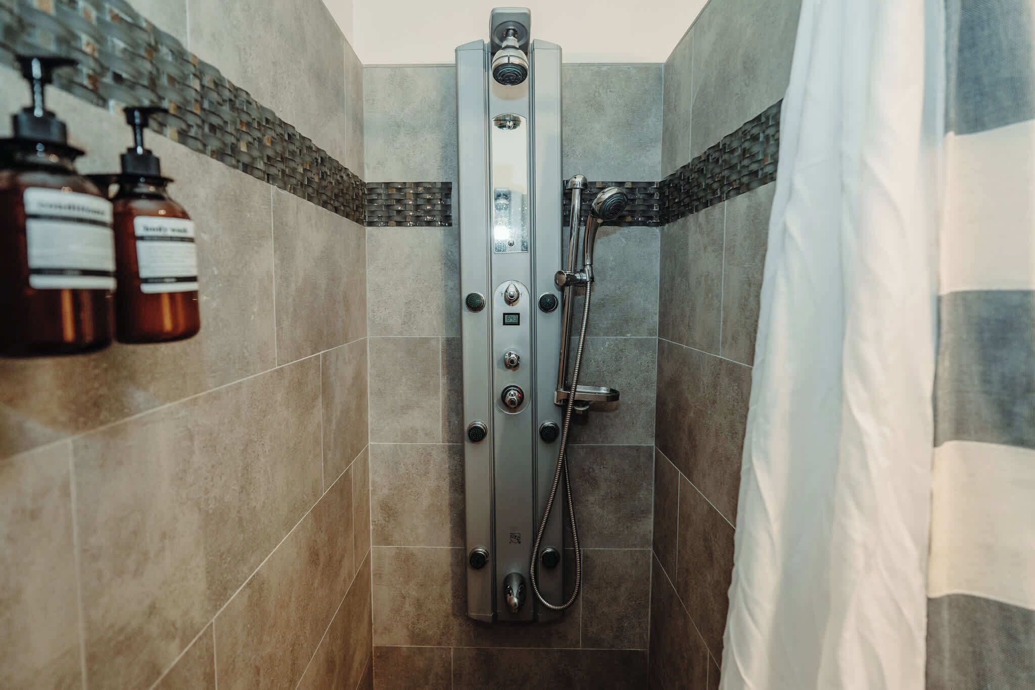 Chuveiro, secador de cabelo, toalhas de banho, shampoo