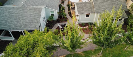 Zona residencial con varias casas, un camino de entrada pavimentado y un pequeño espacio al aire libre con sombrillas.