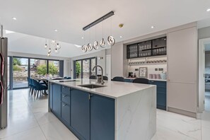 Una cocina moderna con una isla central, armarios integrados y un comedor con vistas.