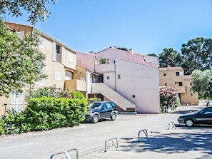 A residential street with multi-story buildings, a parked car, and a staircase leading to an upper level. - Les Lavandes by Interhome (Saint Cyr sur mer Les Lecques)