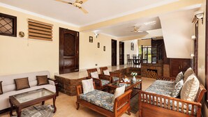 A spacious living room with a sofa, chairs, a coffee table, and a fireplace. - Karinya Villas Scenic Hill View & Garden (Naina Range)