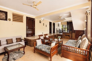 A spacious living room with a sofa, chairs, a coffee table, and a fireplace.
