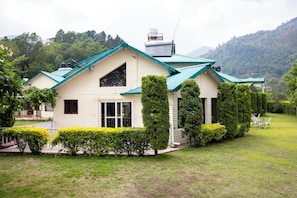 A house with a sloped roof, a chimney, and a well-maintained lawn. - Karinya Villas Scenic Hill View & Garden (Naina Range)