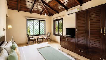 Un dormitorio con cama, televisor, armario y ventilador de techo.