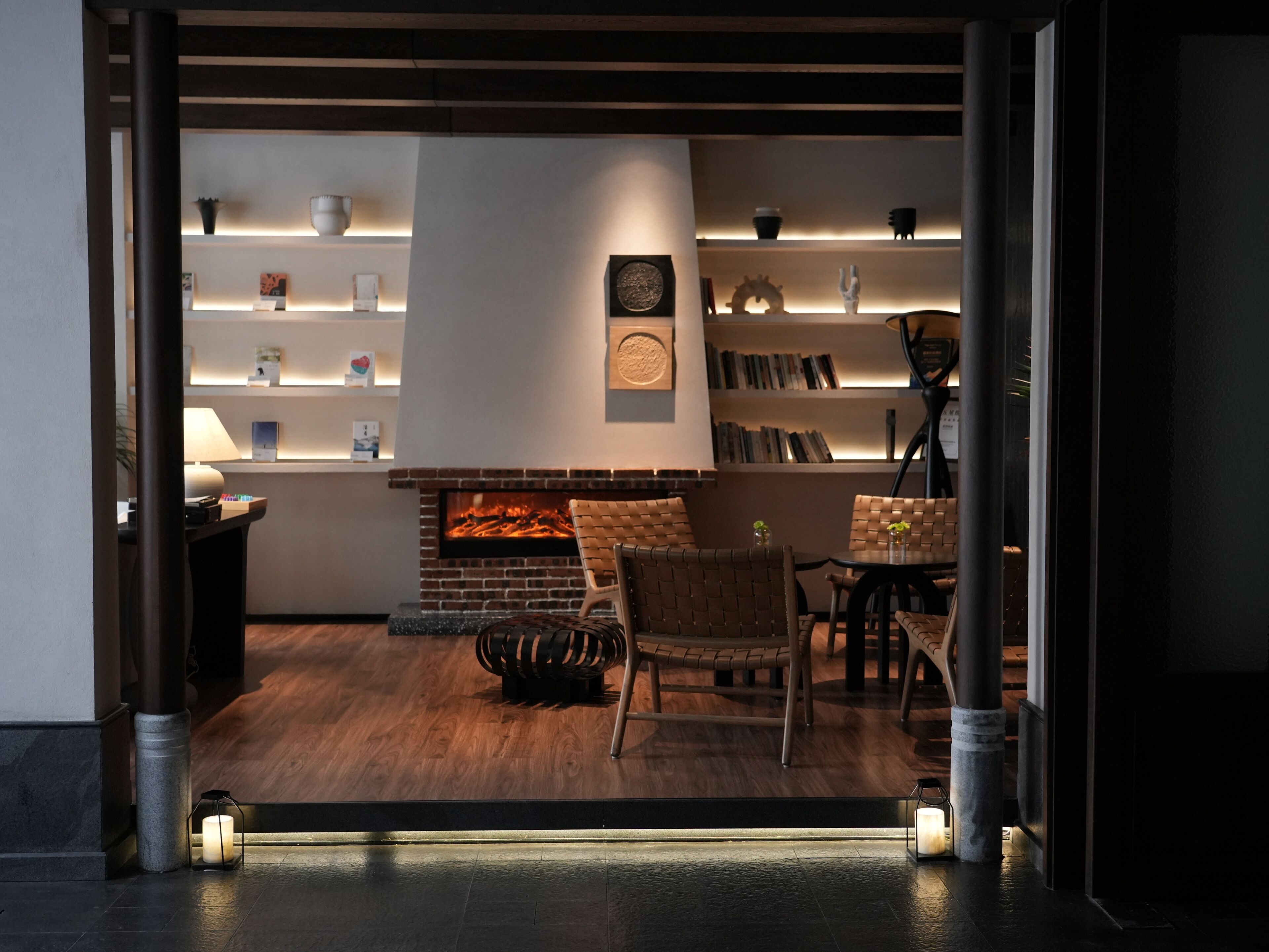 A modern interior with a fireplace, seating area, and bookshelves.