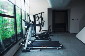 A home gym with exercise equipment including a treadmill, stationary bike, and weight machines. - 6500 Hotel Chaozong Street Wuyi Plaza (Changsha)