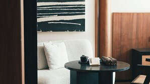 A modern room with a dark round table, a white sofa, and a large abstract painting on the wall. - 6500 Hotel Chaozong Street Wuyi Plaza (Changsha)