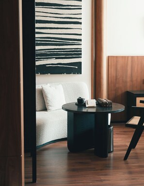 A modern room with a dark round table, a white sofa, and a large abstract painting on the wall. - 6500 Hotel Chaozong Street Wuyi Plaza (Changsha)