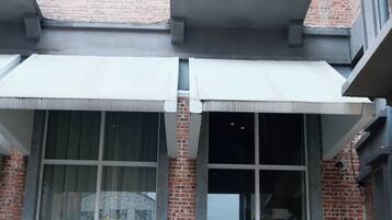 A building with a large glass window and a door with a white frame.
