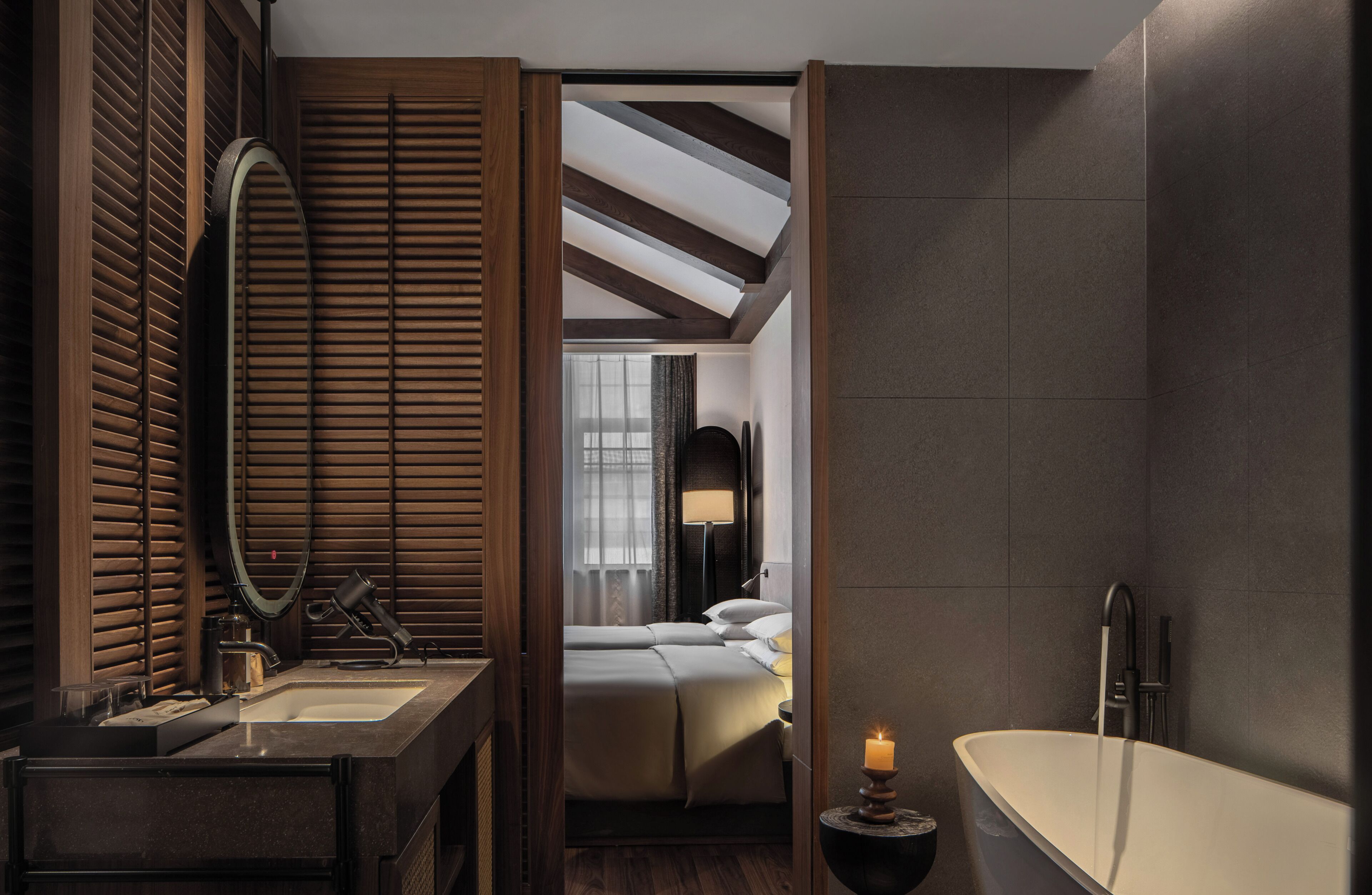 A modern bathroom with a large mirror, a bathtub, and a sink.