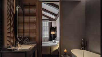 A modern bathroom with a large mirror, a bathtub, and a sink.