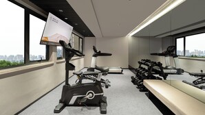 Et moderne fitnesscenter med motionscykler, løbebånd og håndvægte.
