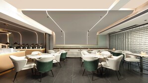 Et moderne restaurantmiljø med et centralt siddeområde, en bardisk og en dekorativ væg.