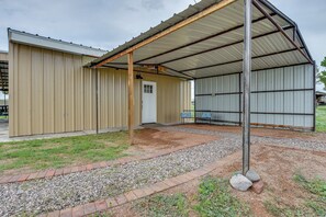 Un bâtiment doté d’un porche couvert, d’une porte et d’un banc.
