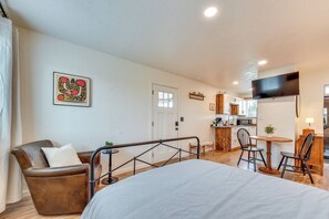A hotel room with a bed, a chair, a small table, a TV, and a kitchenette. - Tranquil Wine Country Getaway w/ Hillside Views (Elgin)