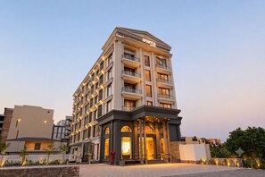 Ein mehrstöckiges Hotel mit markantem Eingang, Balkonen und einer gut beleuchteten Fassade.