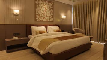 Une chambre d’hôtel moderne avec un grand lit, des tables de chevet, un téléphone et un luminaire fixé au mur.