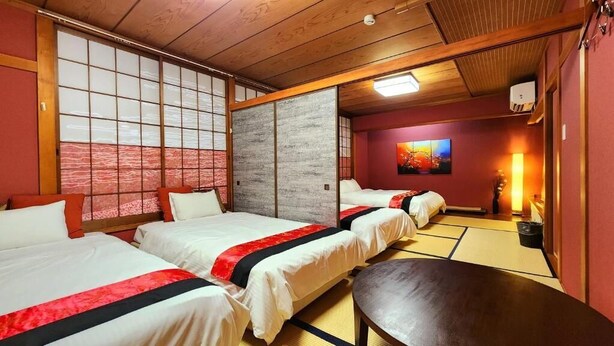 A traditional Japanese-style hotel room with tatami flooring, sliding doors, and a futon bed. - annex kanazawa (Kanazawa)
