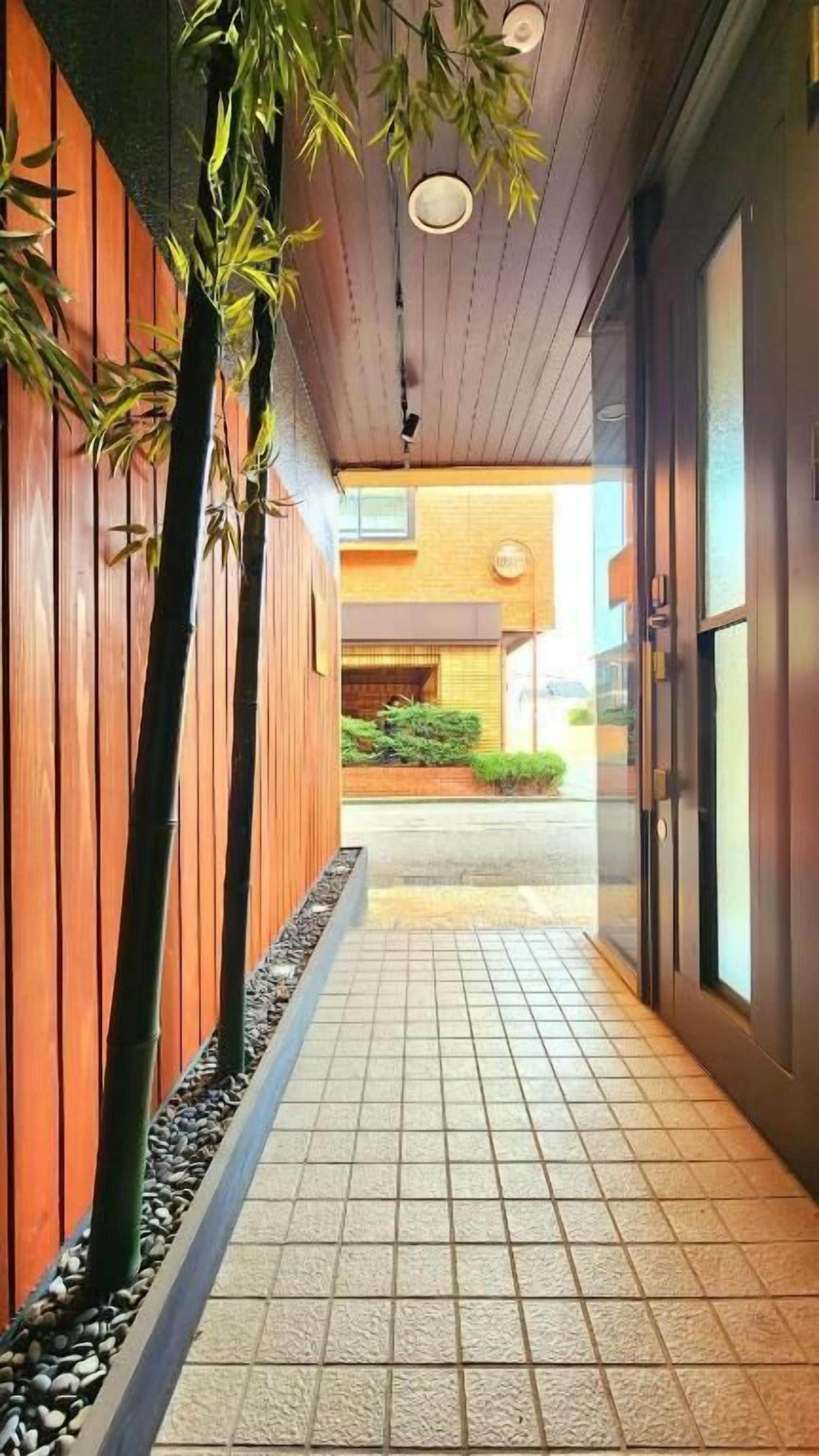 A corridor with wooden paneling, tiled flooring, and a view into a building with a brick exterior.