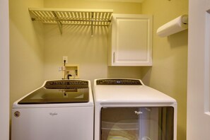 A laundry room with two Whirlpool washers and a dryer, a white door, and a towel rack above the dryers. - Golf-Beach Days, Hot Tub Soaks! Palm Coast Escape! (Palm Coast)