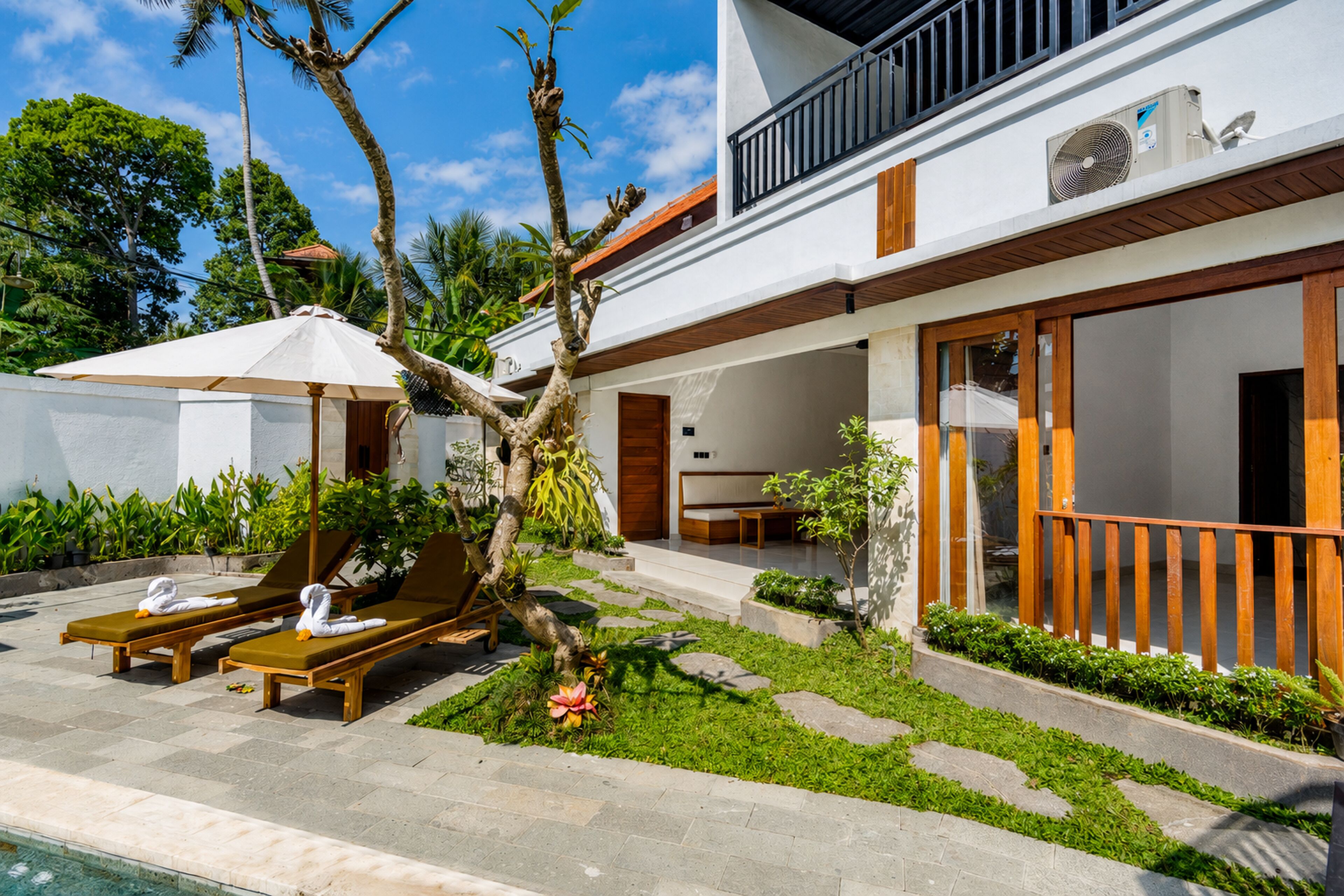 Ein modernes Haus mit Pool, Liegestühlen und Garten.