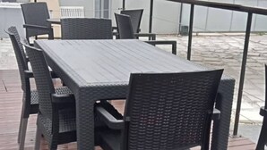 An outdoor patio with a wooden deck, a table, and chairs. - Romantic Retreat Private Room with Shared Pool in Gqeberh (Gqeberha)