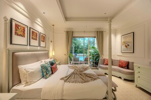 A spacious bedroom with a large bed, multiple pillows, a decorative throw, and artwork on the walls. - ELIVAAS Kensho Colva 4 Bhk with Pool (Colva)