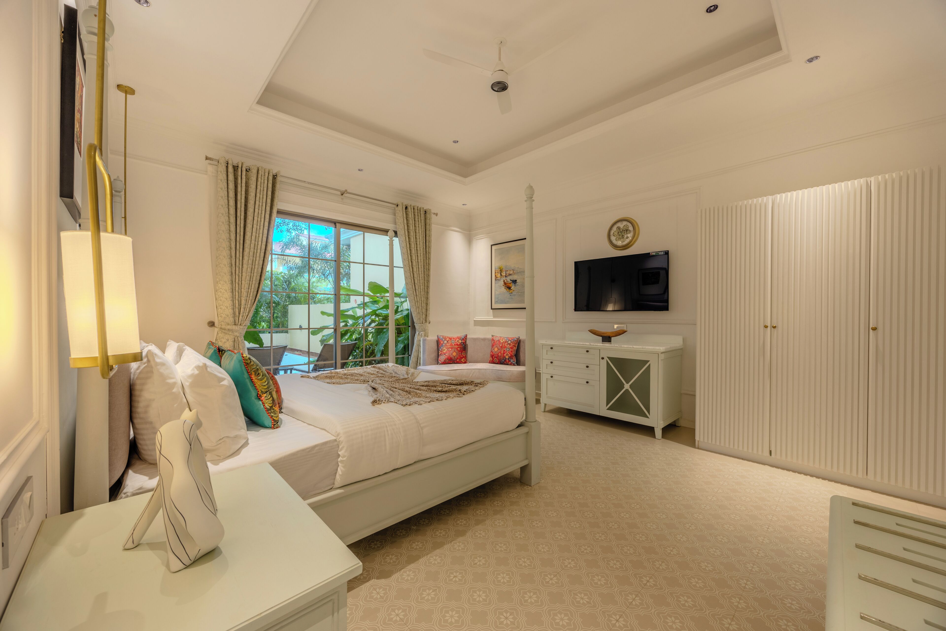 A bedroom with a bed, a bedside table, a TV, and a wardrobe.