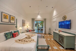 Een hotelkamer met een bed, een televisie, een bureau en uitzicht op het omliggende landschap.