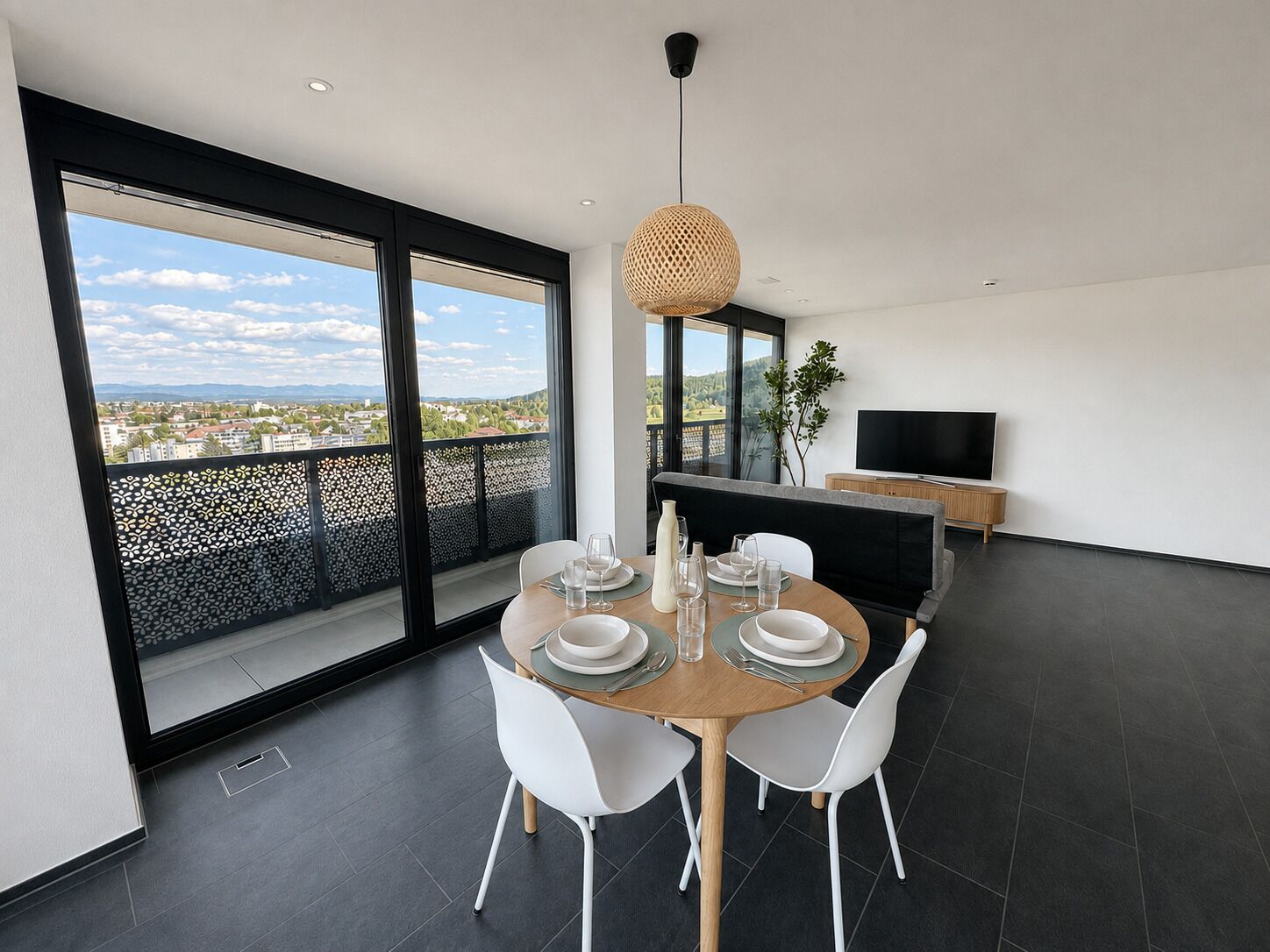 Un espace de restauration moderne avec une grande table, des chaises blanches et une vue sur la ville.