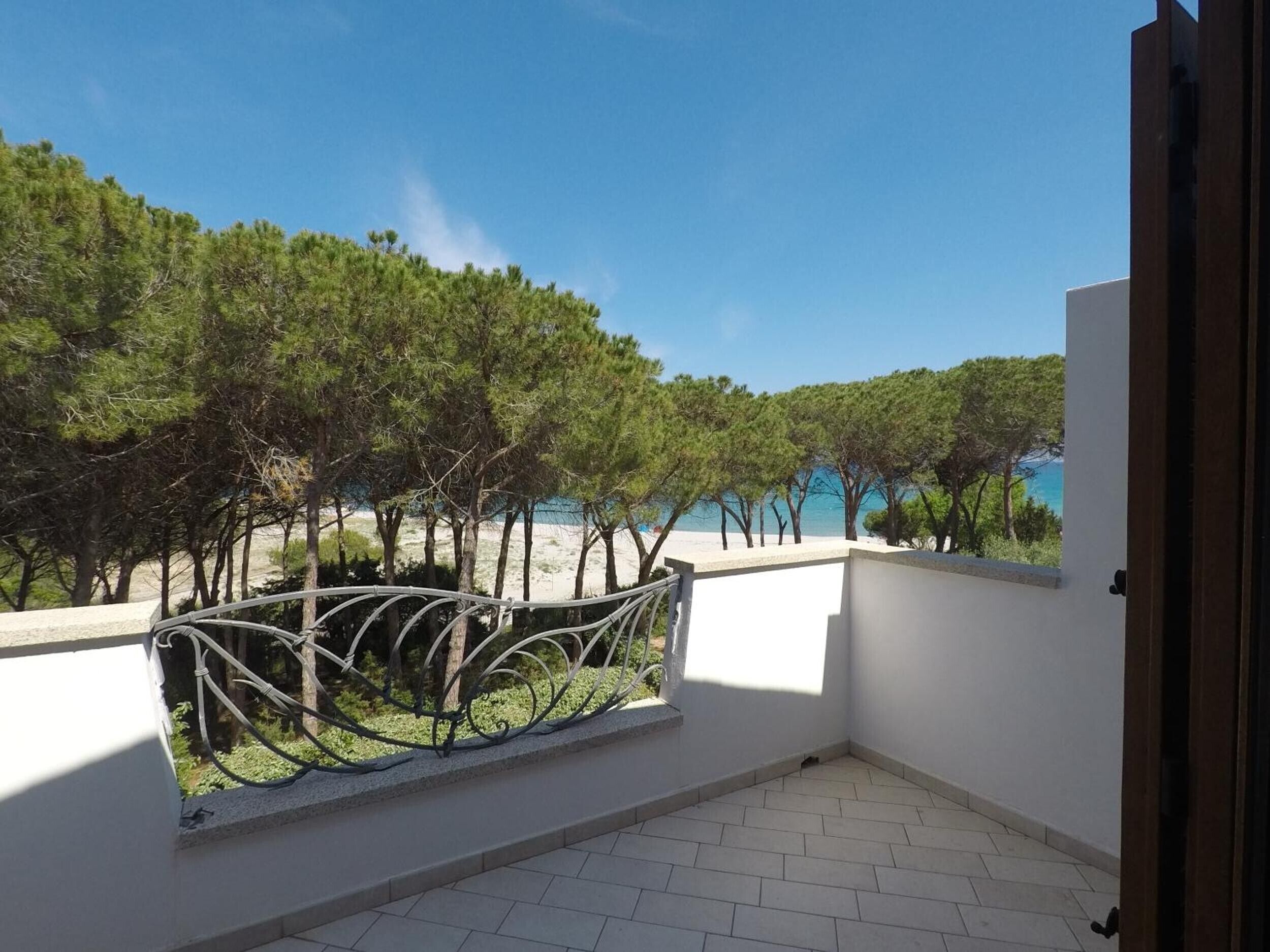 Ein Balkon mit Blick auf Strand und Bäume.