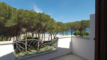 Ein Balkon mit Blick auf Strand und Bäume.