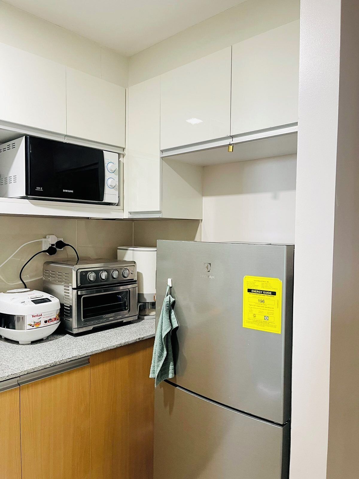 A kitchen with a microwave, toaster, oven, and refrigerator.
