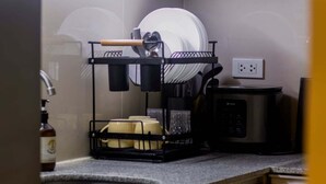 A kitchen with a dish rack, a coffee maker, and a microwave.