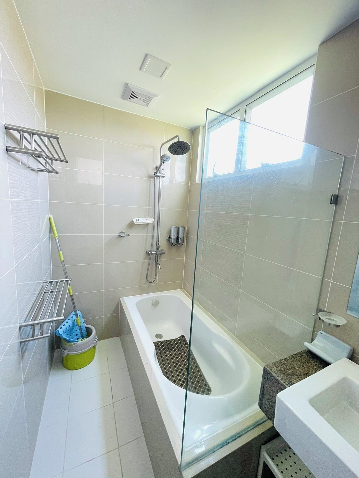 Un baño moderno con ducha envuelta en cristal, una bañera y un tocador con espejo.