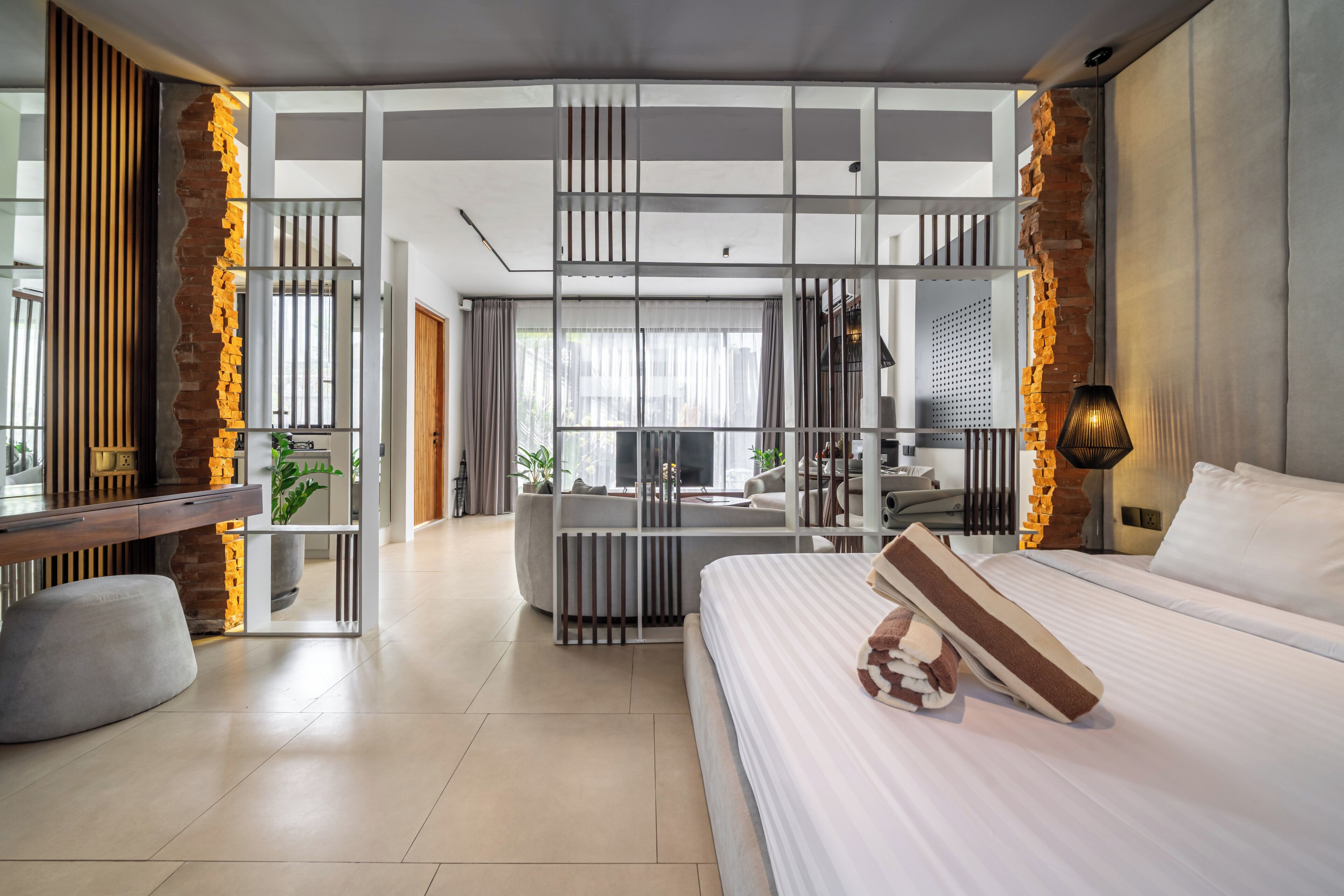 A modern hotel room with a large bed, a desk, and a seating area with a view.