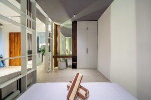 A modern bedroom with a bed, a desk, and a wardrobe. - Sebelas Apartments Ubud (Gianyar)