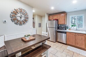 A kitchen with a wooden table, stainless steel appliances, and a clock on the wall. - Flagstaff Getaway 10 Mi to DT: Mini Golf, Fire Pit (Flagstaff)