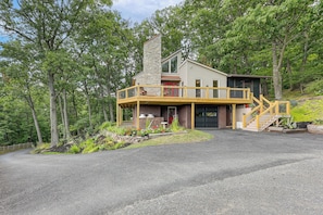 A two-story house with a stone chimney, a wooden deck, and a garage. - Hillside ‘Sunset Vista’ 2 Mi to Dtwn Hughesville (Hughesville)
