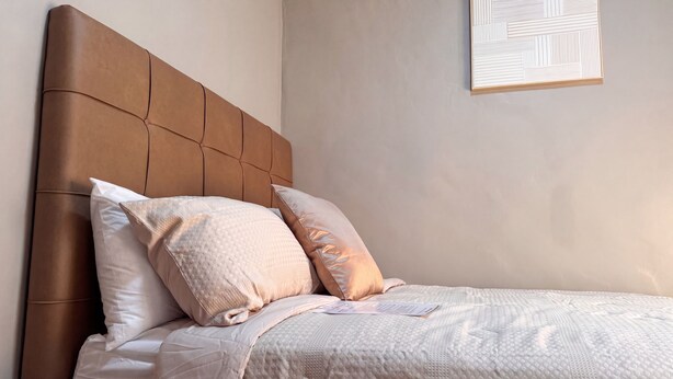 Ein Bett mit Kopfteil, Kissen und Decke.