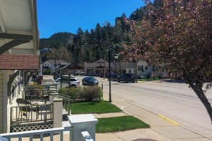 Une rue résidentielle bordée de maisons, avec des voitures garées et un ciel dégagé.