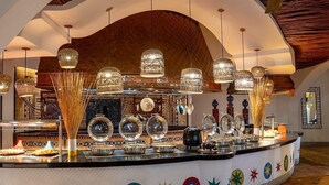 Ein Buffetbereich mit verschiedenen Speisen, einem Deckenventilator und einem gefliesten Boden.