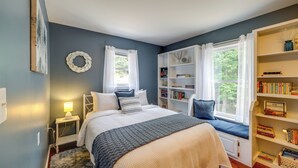 A bedroom with a bed, bedside tables, a bookshelf, and a window with curtains. - Swings, Fire Pit + Views: Shirleysburg Cabin! (Shirleysburg)